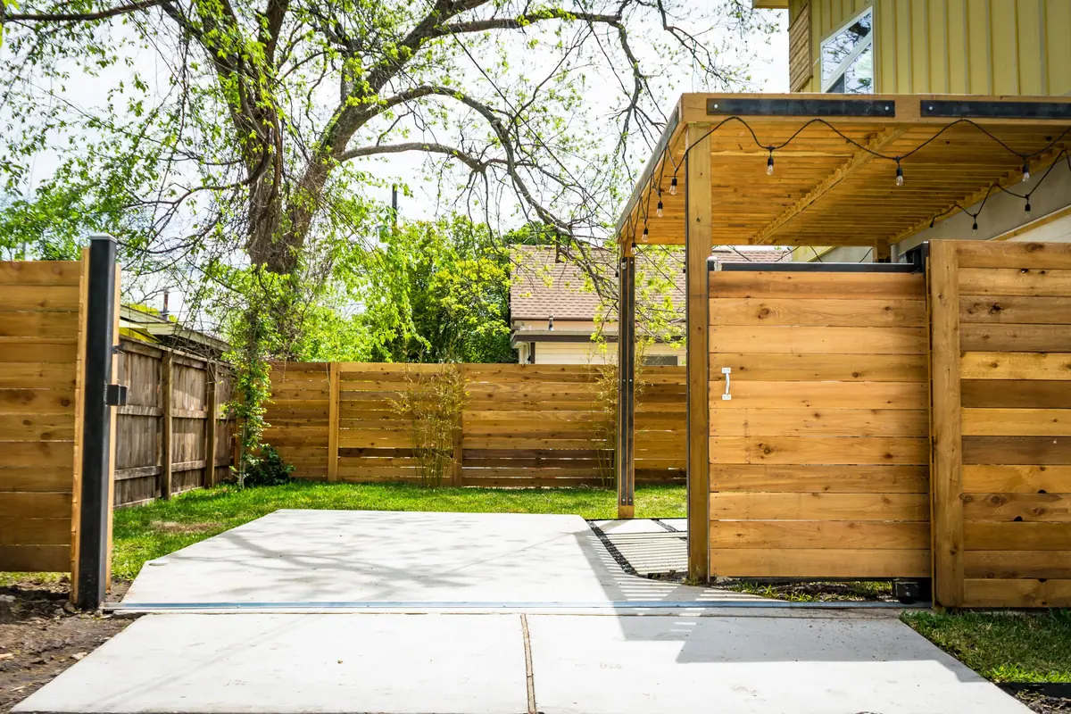 Sunlit wood fence and patio gate in a back yard