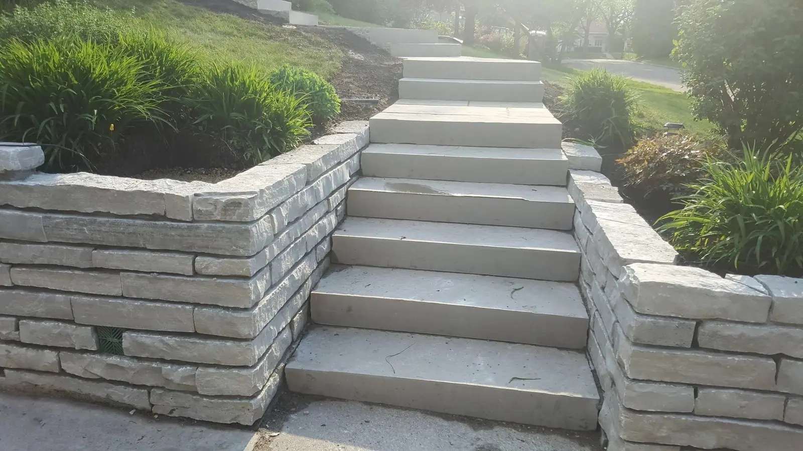 Stone stairway between retaining walls on a landscaped slope